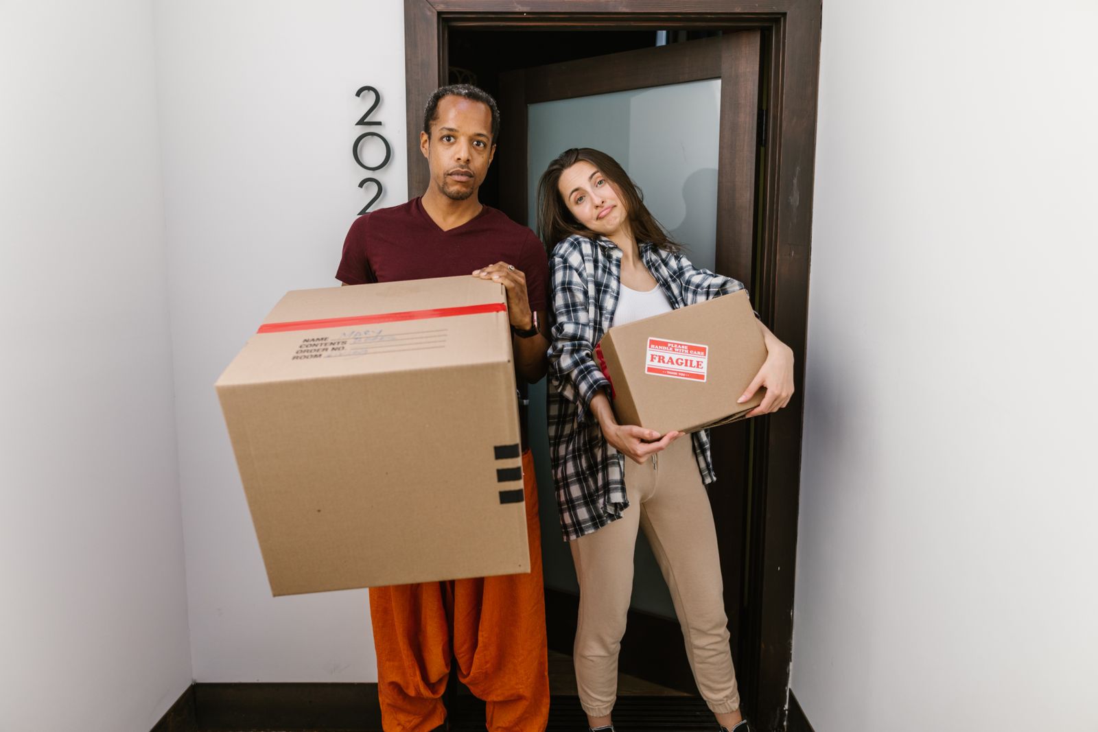 Couple carrying moving boxes